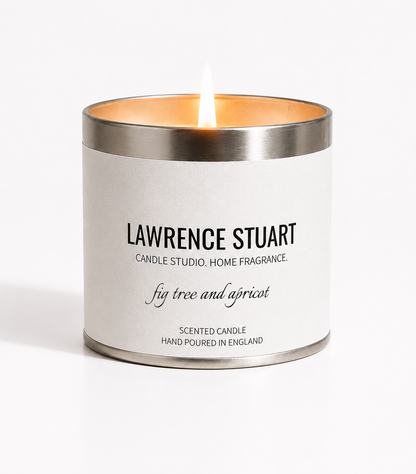 A lit Lawrence Stuart Fig Tree and Apricot candle tin on a white background.