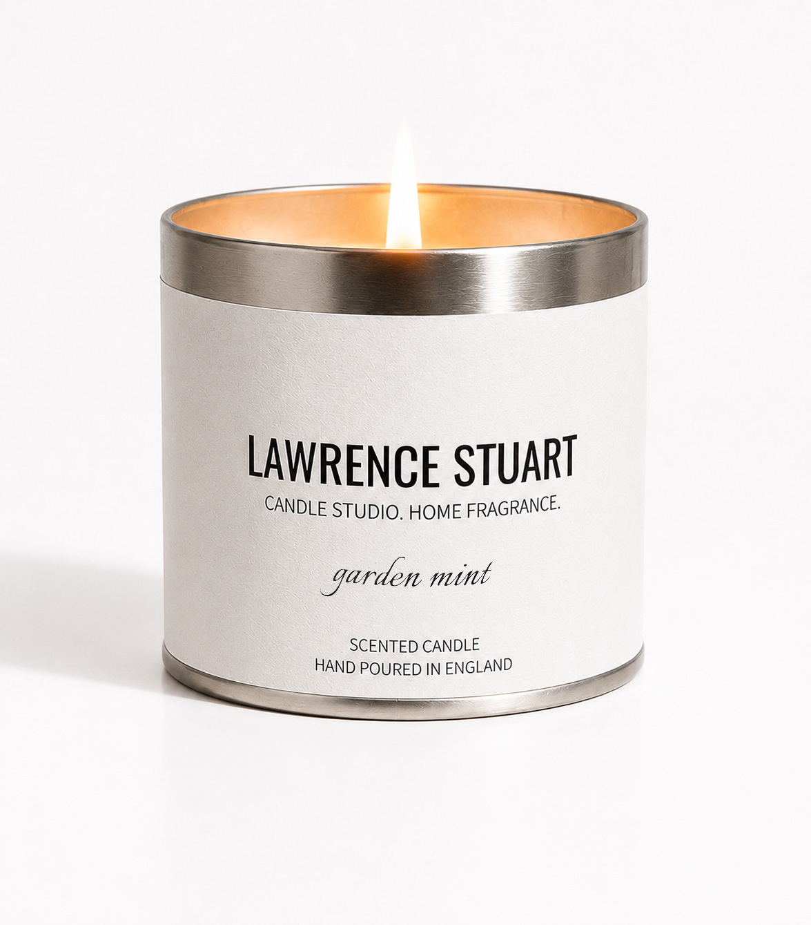 A lit Lawrence Stuart Garden Mint candle tin on a white background.